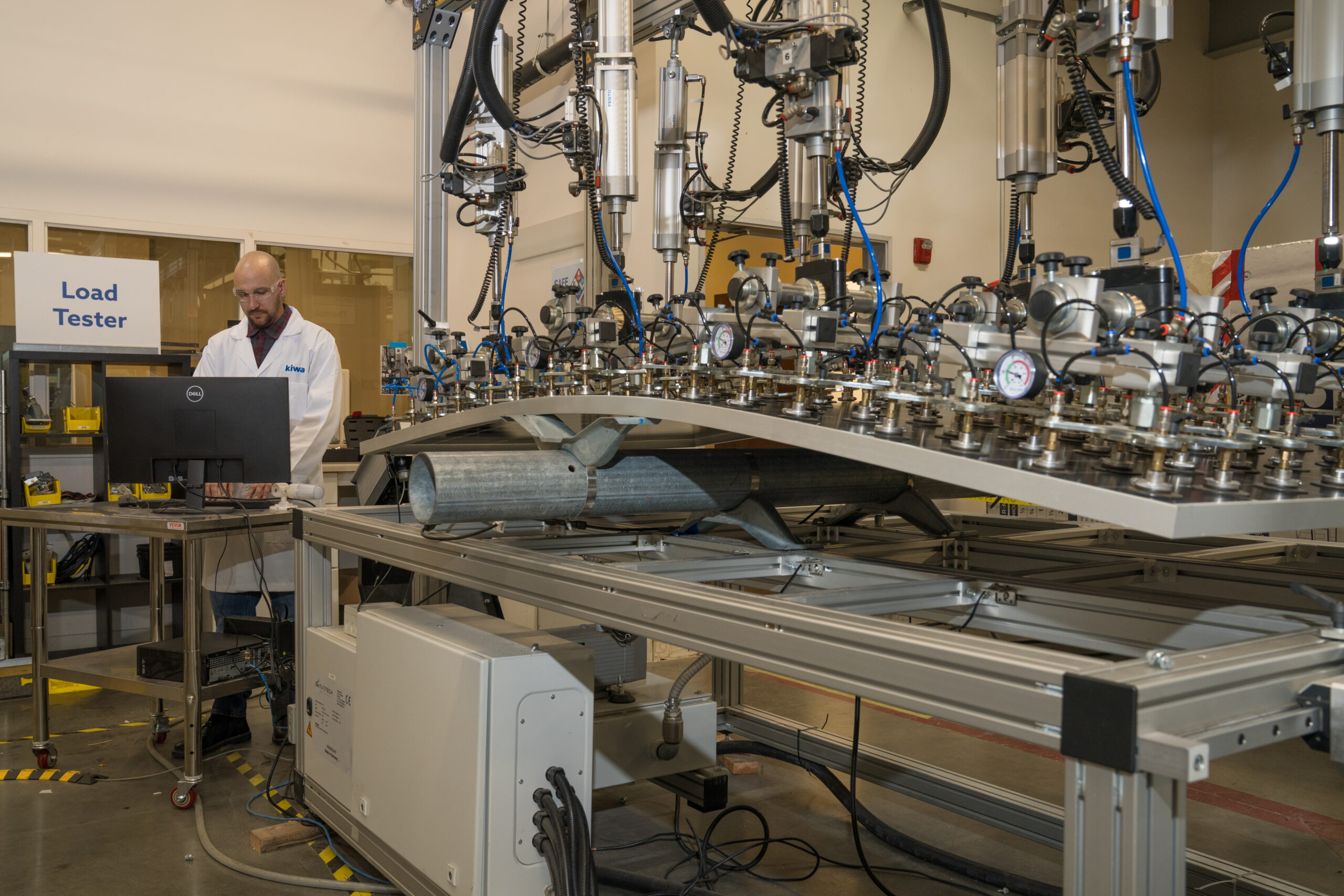 A technician performs mechanical load testing on a solar module in the Kiwa PVEL testing laboratory