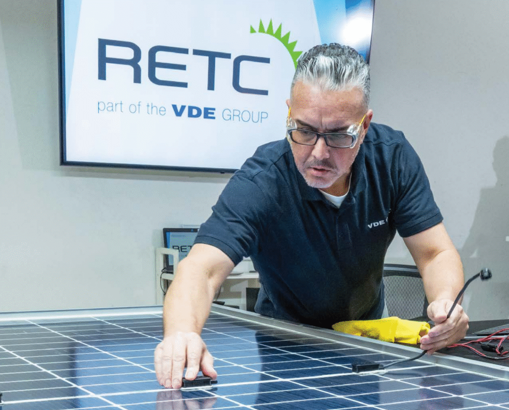 A RETC employee examines a junction box on the back of a bifacial solar module