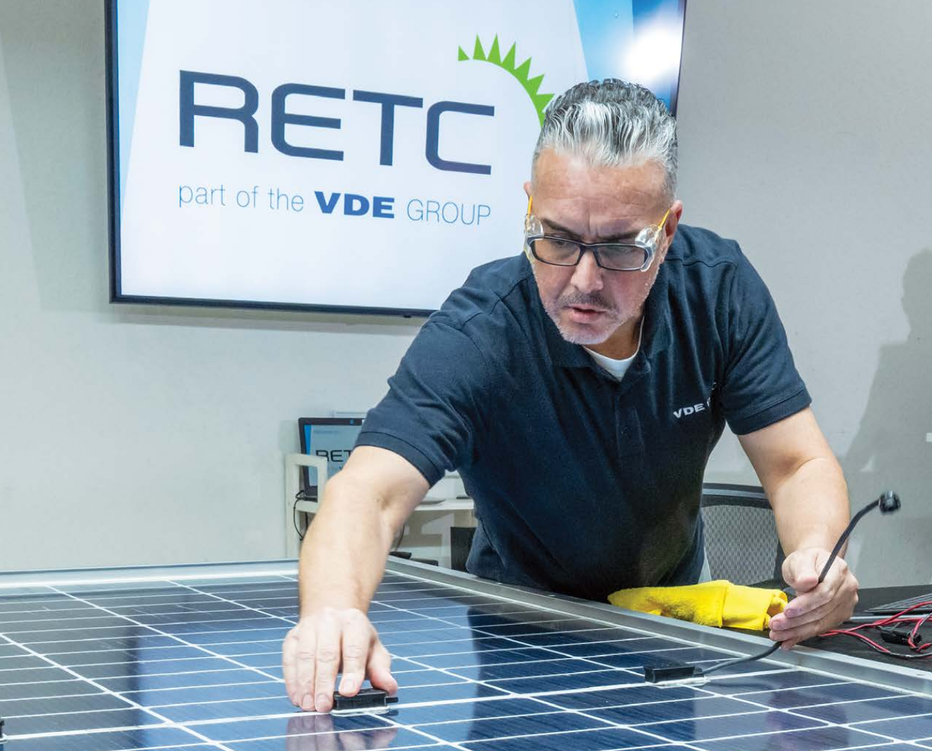 A RETC employee examines a junction box on the back of a bifacial solar module