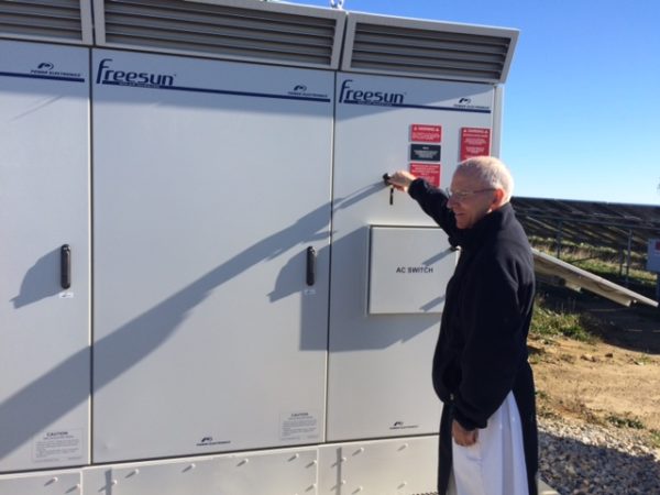 Father Vincent flipping on the switch on the inverters at plant 9. Image: pv magazine.