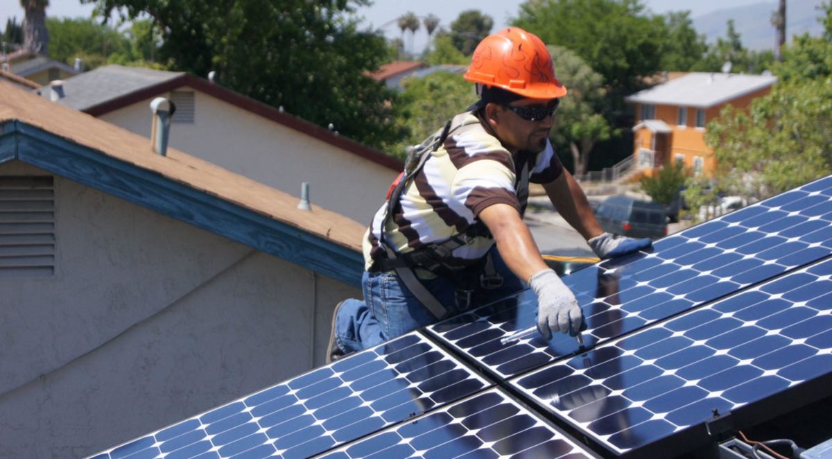 Japanese contractors install solar panels on the Public Works building roof  at Fleet Activities Sasebo, Japan