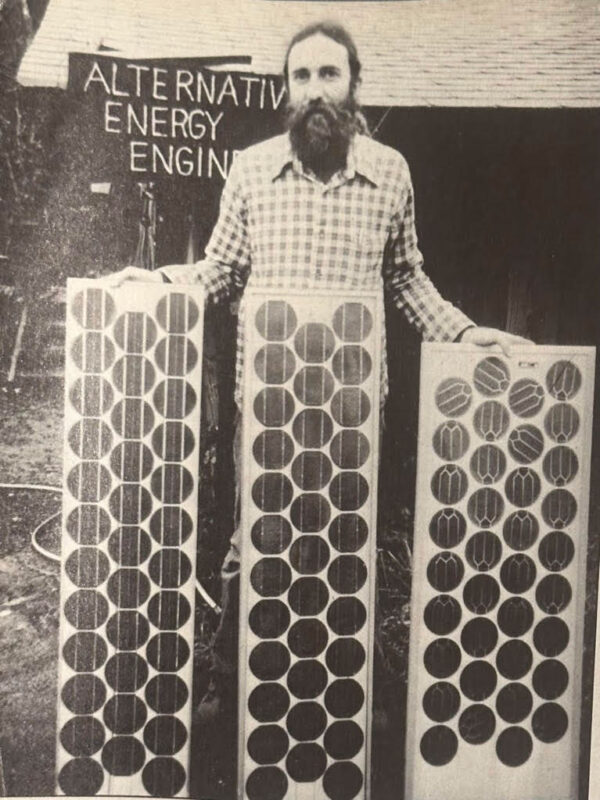 A man standing in front of three solar modules with round cells