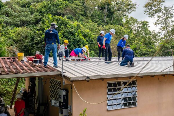 The Mudo Solar team installs rails on a metal roof