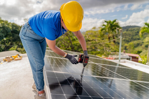 A solar worker tightens a mid clamp in the solar array