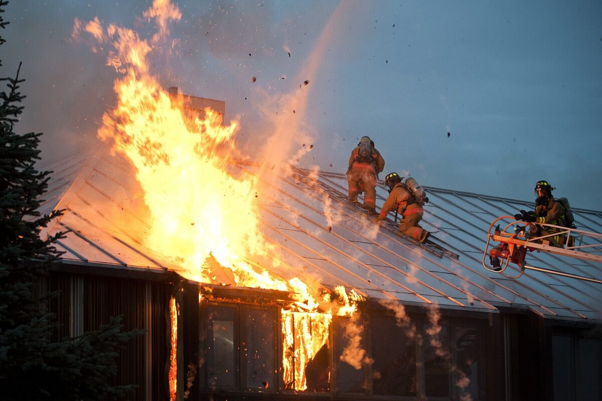 Firefighters work to extinguish a fire on a residential rooftop